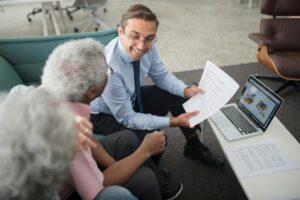 An expert accountant talking to an elderly business owner couple regarding their accounts payable for the month